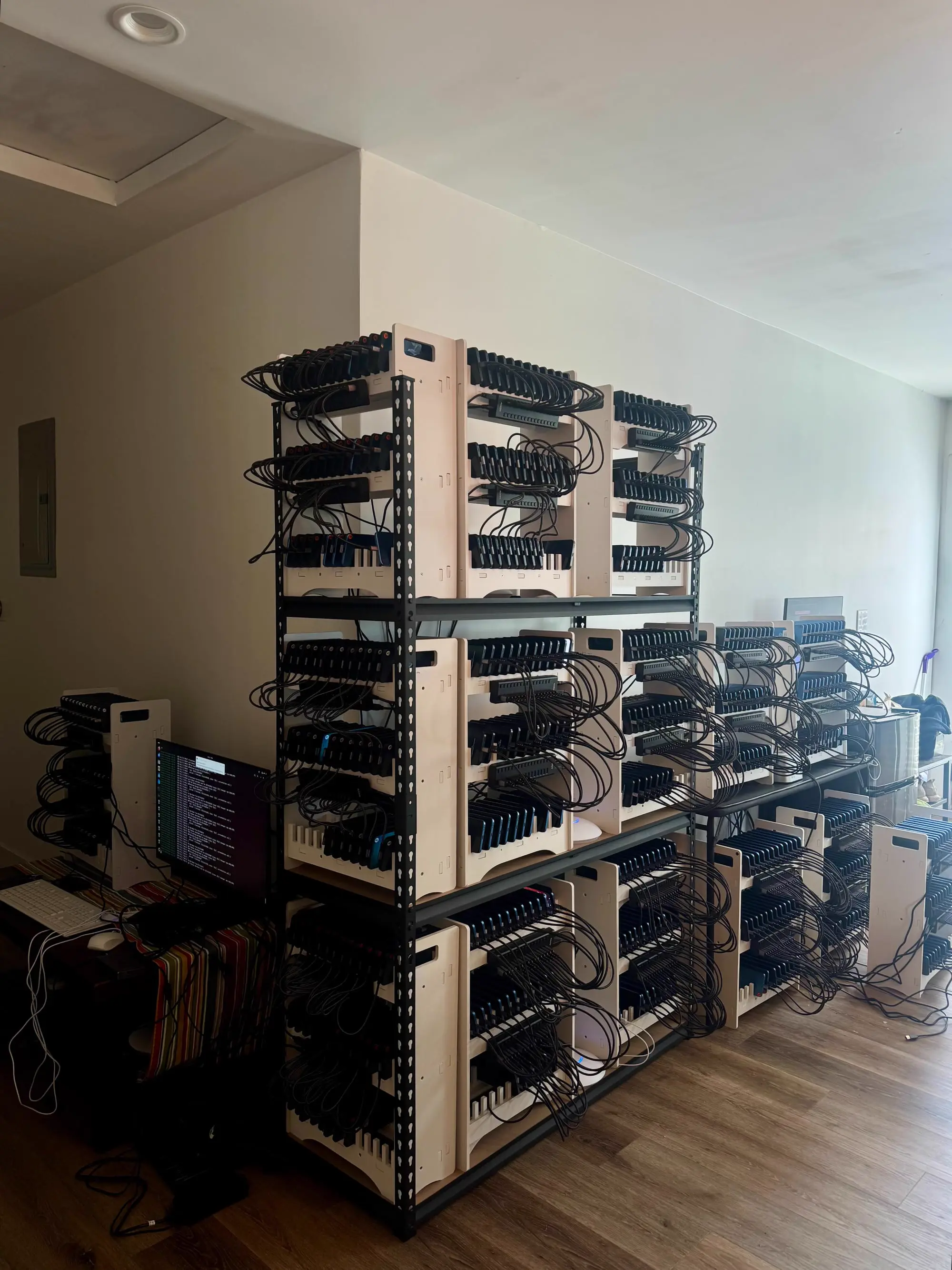 Shelves of phones on charging racks in an apartment, running doublespeed accounts